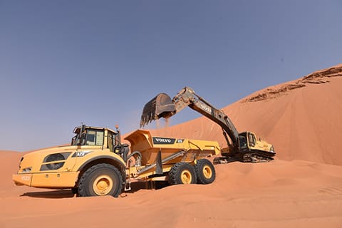 The Volvo excavator and hauler show great teamwork in the desert