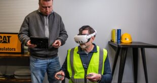 Worker using CAT simulator training with VR headset and controllers in a construction environment.